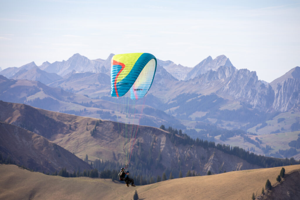 Gleitschirmpilot im Flug über dem Berner Oberland